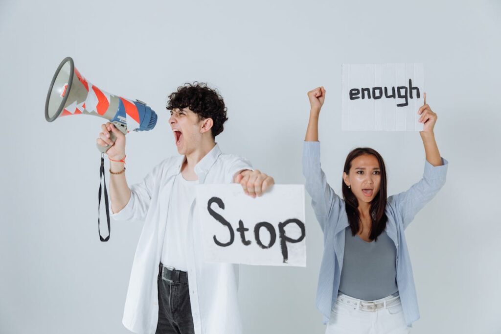 A Man and A women protesting with stop and enough sign boards